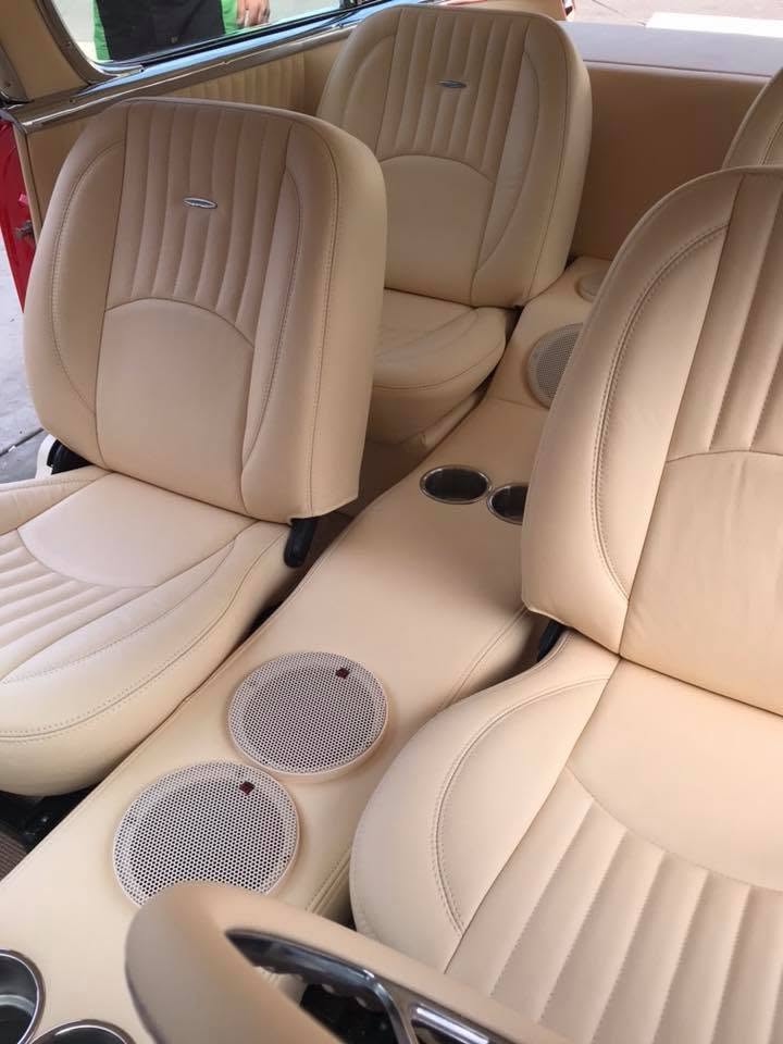 55 Chevy seats Custom tan leather bucket seats with channel stitching and built-in speaker console in a 1955 Chevy Bel Air by Central Valley Upholstery