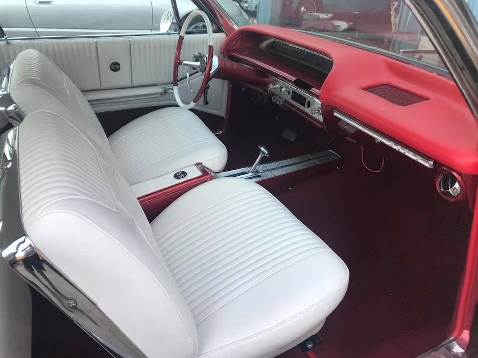 Red and white vinyl Custom white vinyl bench seats and door panels with red dash in a restored 1964 Chevrolet Impala by Central Valley Upholstery