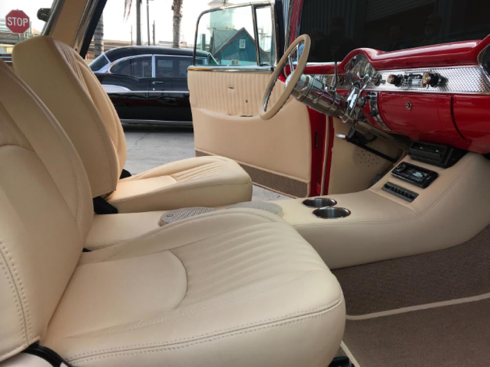 car-upholstery Custom cream leather bucket seats and center console with cup holders in a red 1955 Chevrolet Bel Air by Central Valley Upholstery