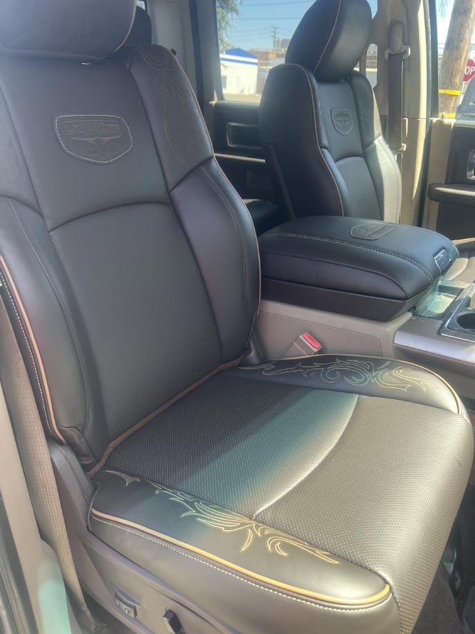 black-car-seats Custom black leather bucket seats with laser-engraved detailing and Longhorn emblem in a Ford truck by Central Valley Upholstery