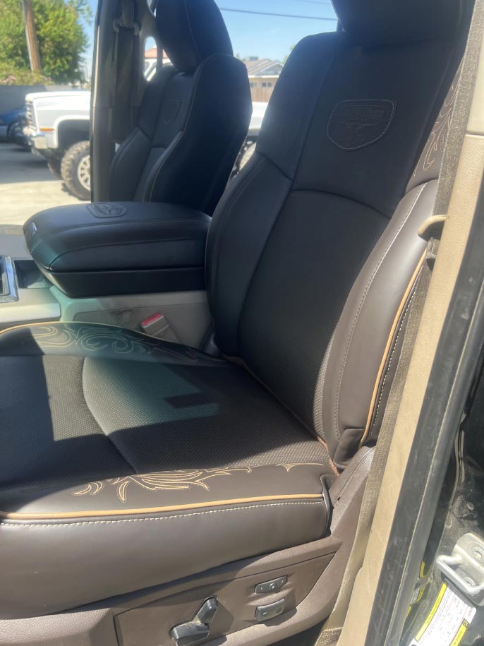 seats-car Custom black and brown leather truck seats with laser-engraved floral stitching in a Ford truck by Central Valley Upholstery