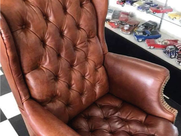 Brown tufted leather wingback chair with nailhead trim, custom upholstered by Central Valley Upholstery in Hanford, CA